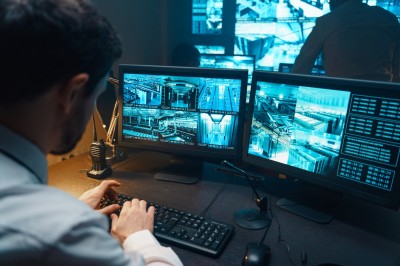 A man watching CCTV feeds while typing
